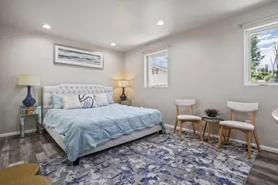 a bedroom with a bed and two chairs and two windows at Spacious family Guesthouse private entry near six flags in Santa Clarita