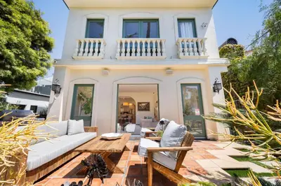 a large white house with a patio with furniture at The Canal Escape - canal-front Italian villa in Los Angeles