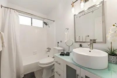 a white bathroom with a sink and a toilet at Los Angeles charming big house, king bed, parking, EV in Los Angeles