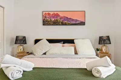 a bedroom with a bed with two lamps and towels at Los Angeles charming big house, king bed, parking, EV in Los Angeles