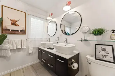 a bathroom with two sinks and a mirror at Los Angeles charming big house, king bed, parking, EV in Los Angeles