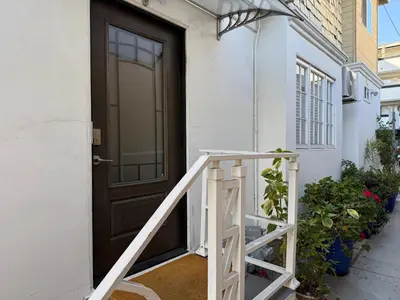 a wooden door on a white house with a stairs at Pasadena Old Town village in Pasadena