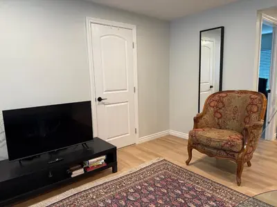 a living room with a chair and a flat screen tv at Pasadena Old Town village in Pasadena