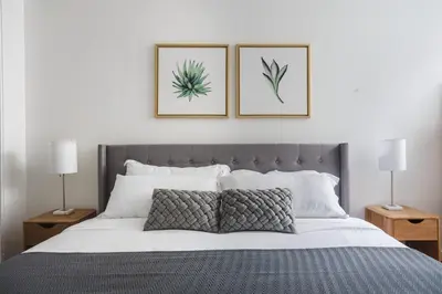 a bedroom with a bed with two pictures on the wall at Blueground Hollywood gym near Walk of Fame LAX-1217 in Los Angeles