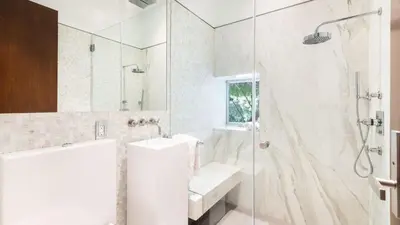 a white bathroom with a shower and a sink at Hollywood Overlook by AvantStay Private Pool Hot Tub Panoramic Views in Los Angeles