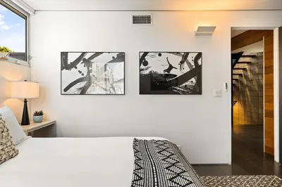 a bedroom with a white bed and three pictures on the wall at Venice Rooftop 5bd 4 bt steps from the beach in Los Angeles