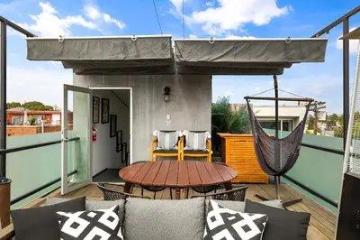 a patio with a hammock and a table on a balcony at Venice Rooftop 5bd 4 bt steps from the beach in Los Angeles