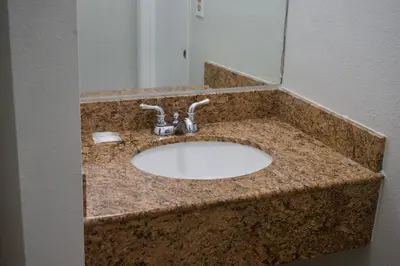a bathroom sink with a granite counter top at Red Carpet Motel By Ontario in Ontario