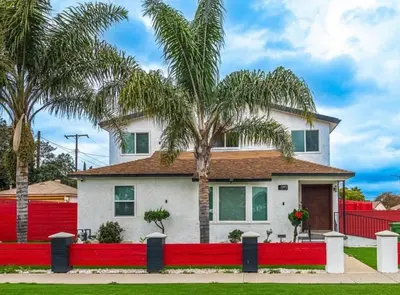 a house with a red fence and palm trees at Modern comfort private room 1 in Los Angeles