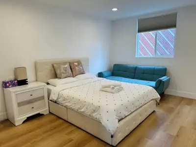 a bedroom with a bed and a blue couch at Cozy Haven private room 3 in Los Angeles