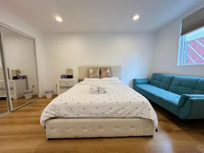 a bedroom with a bed and a blue couch at Cozy Haven private room 3 in Los Angeles