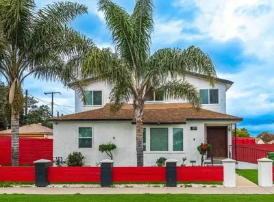 a house with a red fence and palm trees at Chic and Secure Private room in modern home 6 in Los Angeles