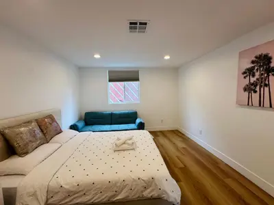 a bedroom with a bed and a blue couch at Chic and Secure Private room in modern home 6 in Los Angeles