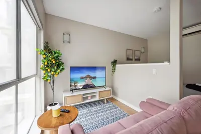 a living room with a pink couch and a tv at Comfy studio near SM Promenade! Free parking! in Los Angeles