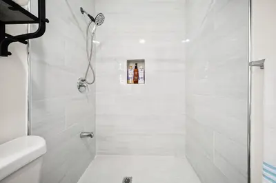 a white bathroom with a shower with a glass door at Idyllic Paradise Near Downtown Los Angeles in Alhambra