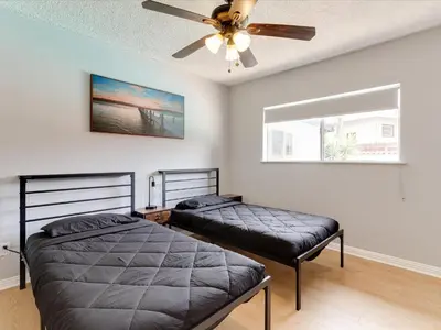 two beds in a bedroom with a ceiling fan at Charming 5 Bedroom Granada Hills House with Pool in Los Angeles