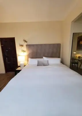 a bedroom with a large bed with a gray headboard at Audrey Studio Apartment in Ktown in Los Angeles