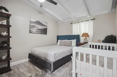 a bedroom with a bed and a crib at The Perfect Vacation Spot Near Six Flags Magic Mountain in Santa Clarita