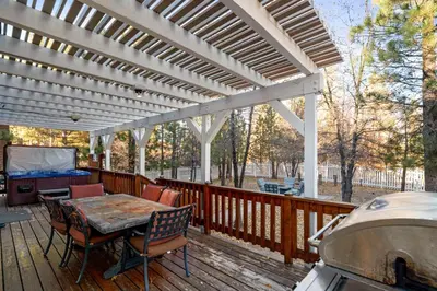 a patio with a table and chairs and a grill at Hillcrest HappyNest - Hot tub, fire pit, gas grill in Big Bear Lake
