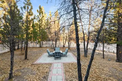 a patio with two chairs and a table in a park at Hillcrest HappyNest - Hot tub, fire pit, gas grill in Big Bear Lake