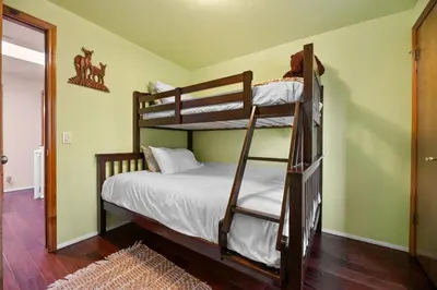 a bedroom with two bunk beds in a room at Hillcrest HappyNest - Hot tub, fire pit, gas grill in Big Bear Lake