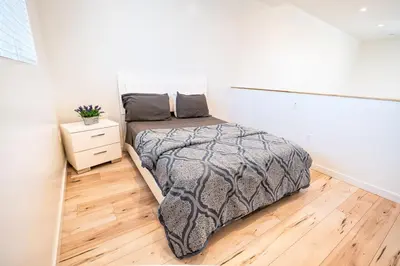 a bedroom with a bed and a wooden floor at Chic Modern Loft in Hollywood 1 Bedroom with Balcony & Free Secure Parking in Los Angeles