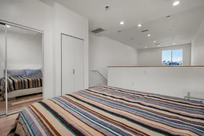 a white bedroom with a bed and a window at Stylish Modern one Bedroom Hollywood Loft With in unite washer dryer & Balcony in Los Angeles