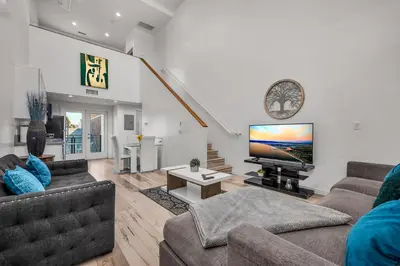 a living room with two couches and a flat screen tv at 1-Bedroom Lofts in Hollywood Modern Design, Balcony, Parking & Hollywood Sign in Los Angeles