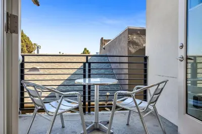 a patio with two chairs and a table on a balcony at 1-Bedroom Lofts in Hollywood Modern Design, Balcony, Parking & Hollywood Sign in Los Angeles