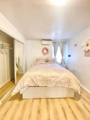 a bedroom with a large bed in a white room at Pink Cozy house 2 bedrooms in Rosemead
