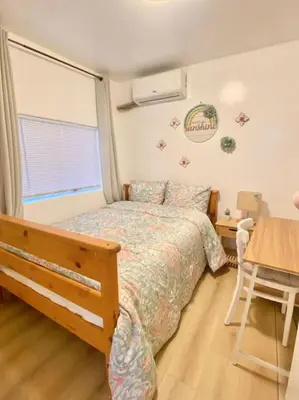 a bedroom with a bed and a table and a window at Pink Cozy house 2 bedrooms in Rosemead
