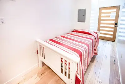 a small bedroom with a bed with a striped blanket at Nice 2 Bedroom 3 Level Loft in Central Location Close to Downtown LA Free Gated Parking Full Kitchen in Los Angeles