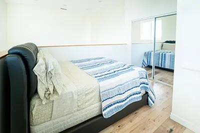 a bedroom with a bed with a blanket on it at Unique 3-Level Loft with One bedroom & Two Full Bathroom in Los Angeles