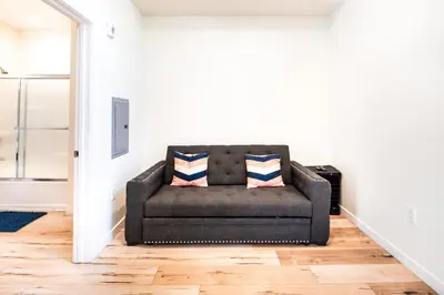 a black couch sitting in a living room at Unique 3-Level Loft with One bedroom & Two Full Bathroom in Los Angeles