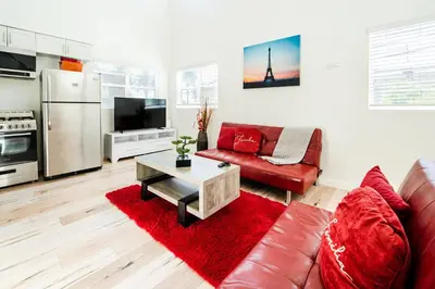 a living room with a red couch and a table at Modern 3 Bedroom 3 Level Loft in Hollywood Sleeps 10 Free Gated Parking Full Kitchen in Los Angeles