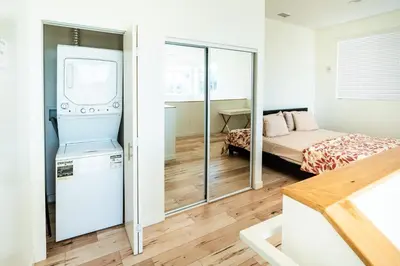 a small bedroom with a bed and a refrigerator at Modern 3 Bedroom 3 Level Loft in Hollywood Sleeps 10 Free Gated Parking Full Kitchen in Los Angeles