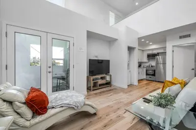 a living room with a couch and a table at Chic 2 Bedroom 2 Bathroom 3 Level Loft Style Condo by Hollywood Free Gated Parking Full kitchen in Los Angeles