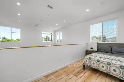 a bedroom with white walls and a bed and windows at Chic 2 Bedroom 2 Bathroom 3 Level Loft Style Condo by Hollywood Free Gated Parking Full kitchen in Los Angeles