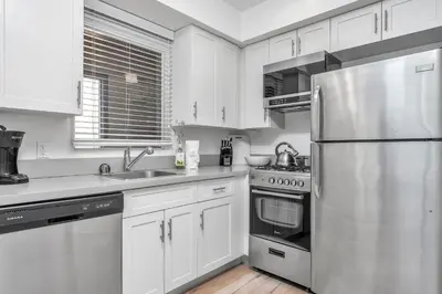 a kitchen with white cabinets and a stainless steel refrigerator at Chic 2 Bedroom 2 Bathroom 3 Level Loft Style Condo by Hollywood Free Gated Parking Full kitchen in Los Angeles