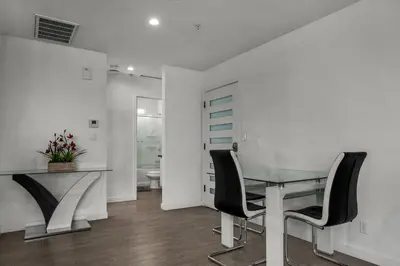 a dining room with a glass table and black chairs at Fully Furnished 1 Bedroom Apartment with Full Bathroom in Koreatown Free Gated Parking Full Kitchen in Los Angeles
