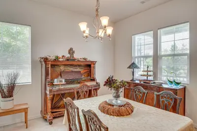 a dining room with a table and a piano at Rio Bravo Country Club Home in Bakersfield with Pool in Bakersfield