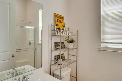 a bathroom with a toilet and a sink and a mirror at Rio Bravo Country Club Home in Bakersfield with Pool in Bakersfield