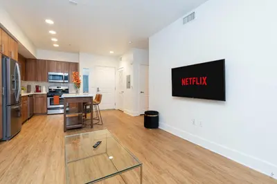 a kitchen and living room with a television on a wall at The Modern Suite Residences in Glendale