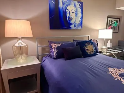 a bedroom with a purple bed with a lamp on it at Beverly Estates in Los Angeles