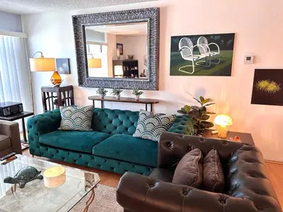 a living room with a blue couch and a mirror at Beverly Estates in Los Angeles