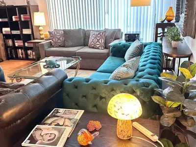 a living room with a blue couch and a table at Beverly Estates in Los Angeles