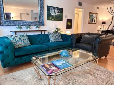 a living room with a blue couch and a glass table at Beverly Estates in Los Angeles