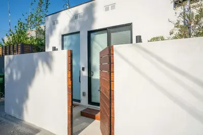 a house with a white wall and a fence at Brand New Studio in Mar Vista in Los Angeles