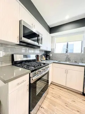 a kitchen with a stove and a microwave at Elegant 4-Bedroom Family Home - Oak2 - LAD in Los Angeles