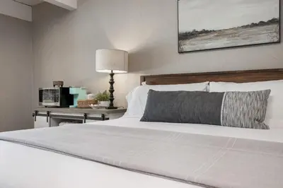 a bedroom with a white bed and a table with a lamp at Big Pine Suite CN Lodge R#1 in Ponderosa